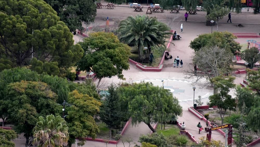 Parque con árboles alrededor y gente paseando