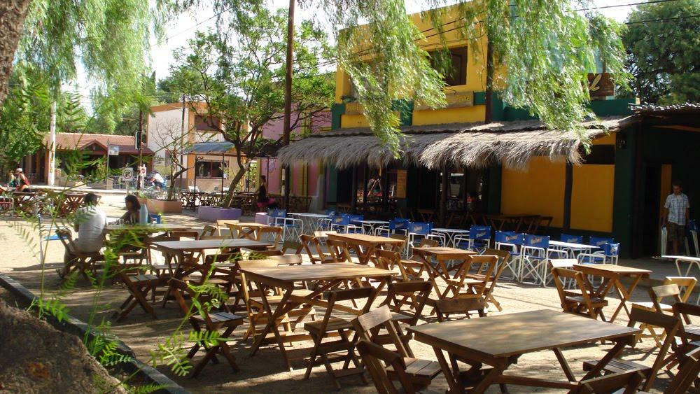 Plaza de comidas con mesas y sillas y gente alrededor